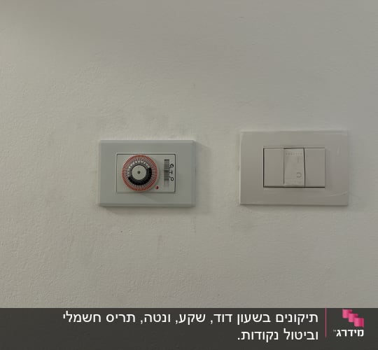 מתג חשמל ולוח בקרה על קיר לבן